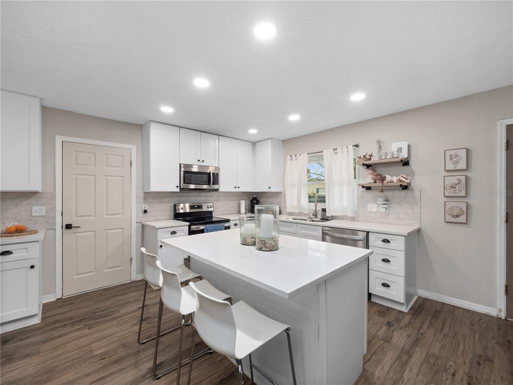 2733 Middle Street Orlando, FL 32807 - Photo 10 of 23 a kitchen with a sink a stove a refrigerator and white cabinets with wooden floor