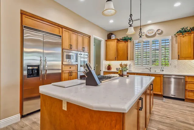 a kitchen with stainless steel appliances granite countertop a sink and a stove