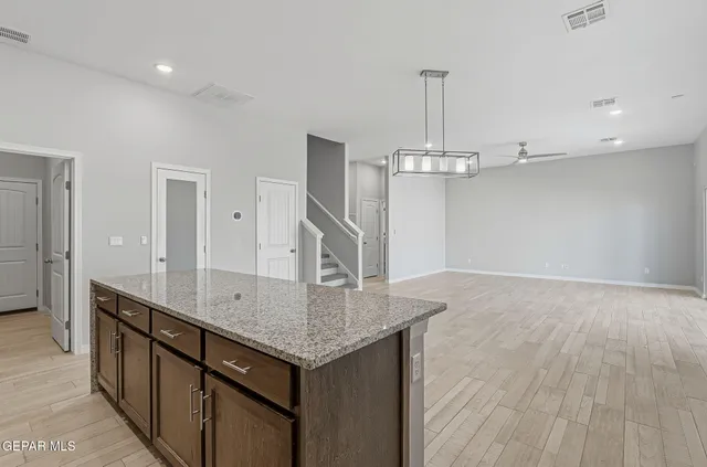 a kitchen with stainless steel appliances granite countertop a sink refrigerator and cabinets