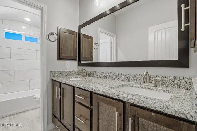 a bathroom with a granite countertop sink and a mirror