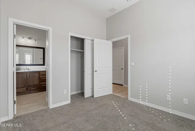 an empty room with closet and a bathroom