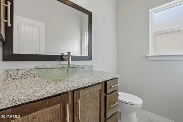 a bathroom with a sink a toilet and a mirror