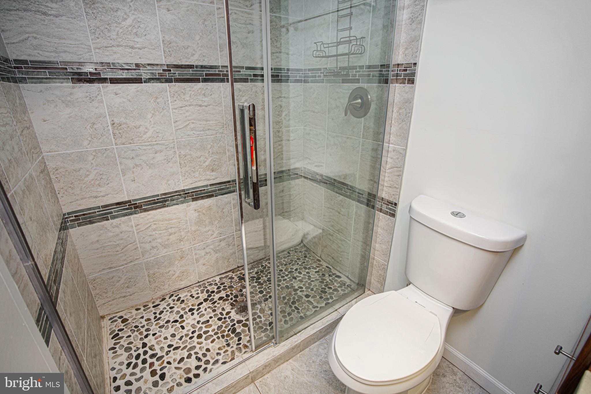 4000 Gypsy Lane, Unit 110C Philadelphia, PA 19129 - Photo 16 of 25 a white toilet sitting next to a shower