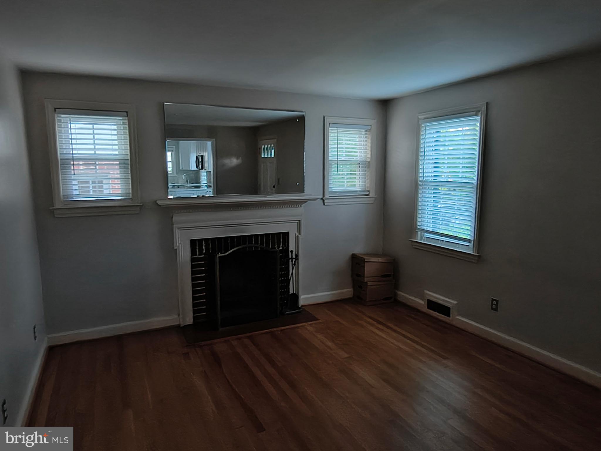 9316 Sudbury Road Silver Spring, MD 20901 - Photo 3 of 19 a view of an empty room with wooden floor and a window