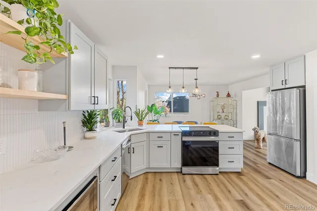 a kitchen with stainless steel appliances granite countertop a stove a sink dishwasher and a refrigerator