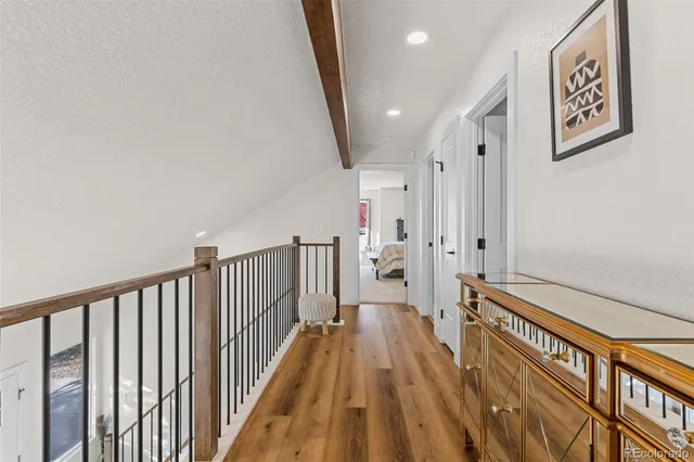 a view of a hallway with wooden floor and staircase