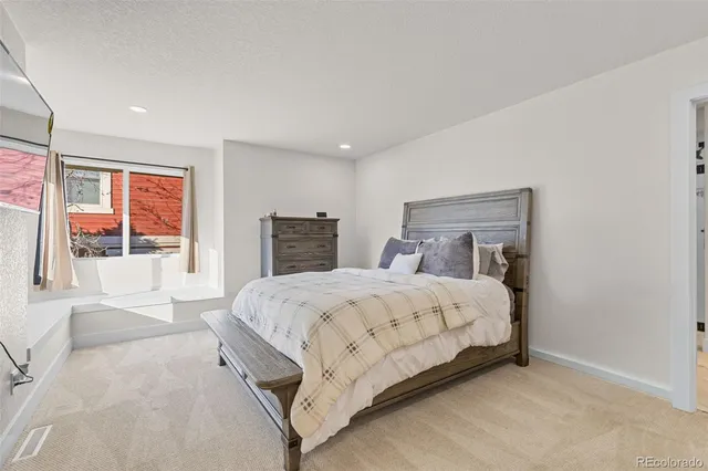a bedroom with a large bed and wooden floor