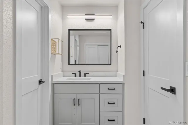 a bathroom with a sink vanity and a mirror