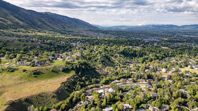 1365 Sumac Drive Logan, UT 84321 - Photo 54 of 66 Expansive aerial perspective showcasing a verdant valley setting with a dense tree canopy