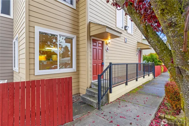 a view of a house with wooden fence and a tree