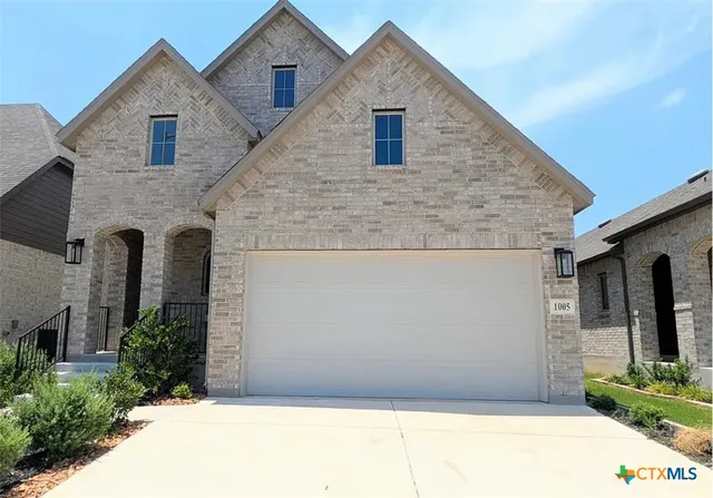 a front view of a house with plants