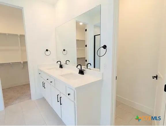 a spacious bathroom with a double vanity sink and mirror