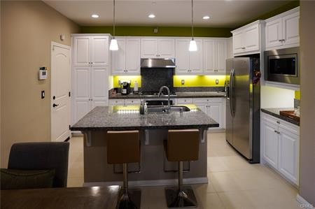 2963 Walking Beam Place Brea, CA 92821 - Photo 5 of 25 a kitchen with stainless steel appliances granite countertop a stove a sink and a microwave