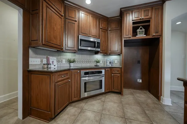a kitchen with stainless steel appliances granite countertop a refrigerator and cabinets