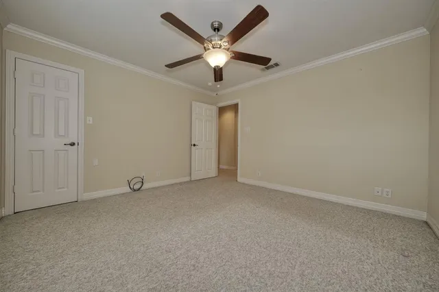 an empty room with ceiling fan and window
