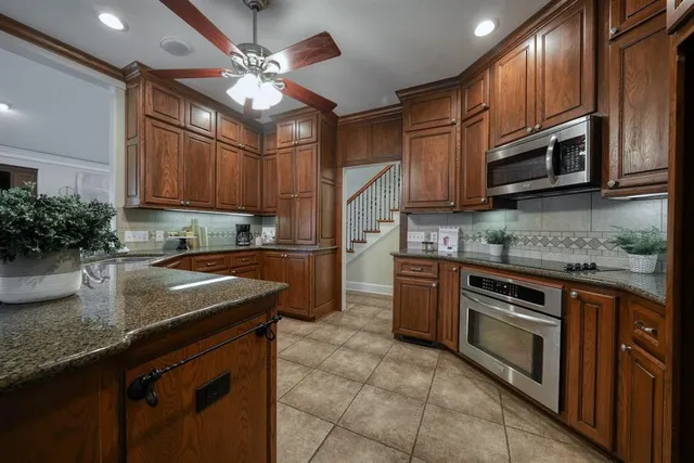 a kitchen with stainless steel appliances granite countertop a sink a stove top oven a counter space and cabinets