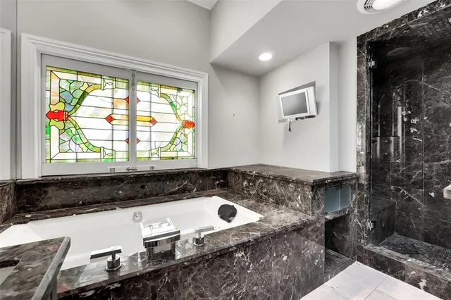a bathroom with a granite countertop sink and a window