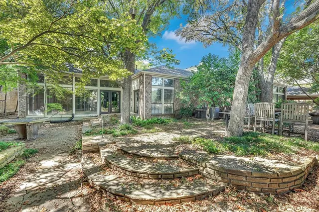 a backyard of a house with garden and outdoor seating