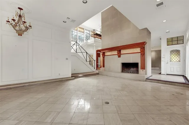 an empty room with windows and fireplace