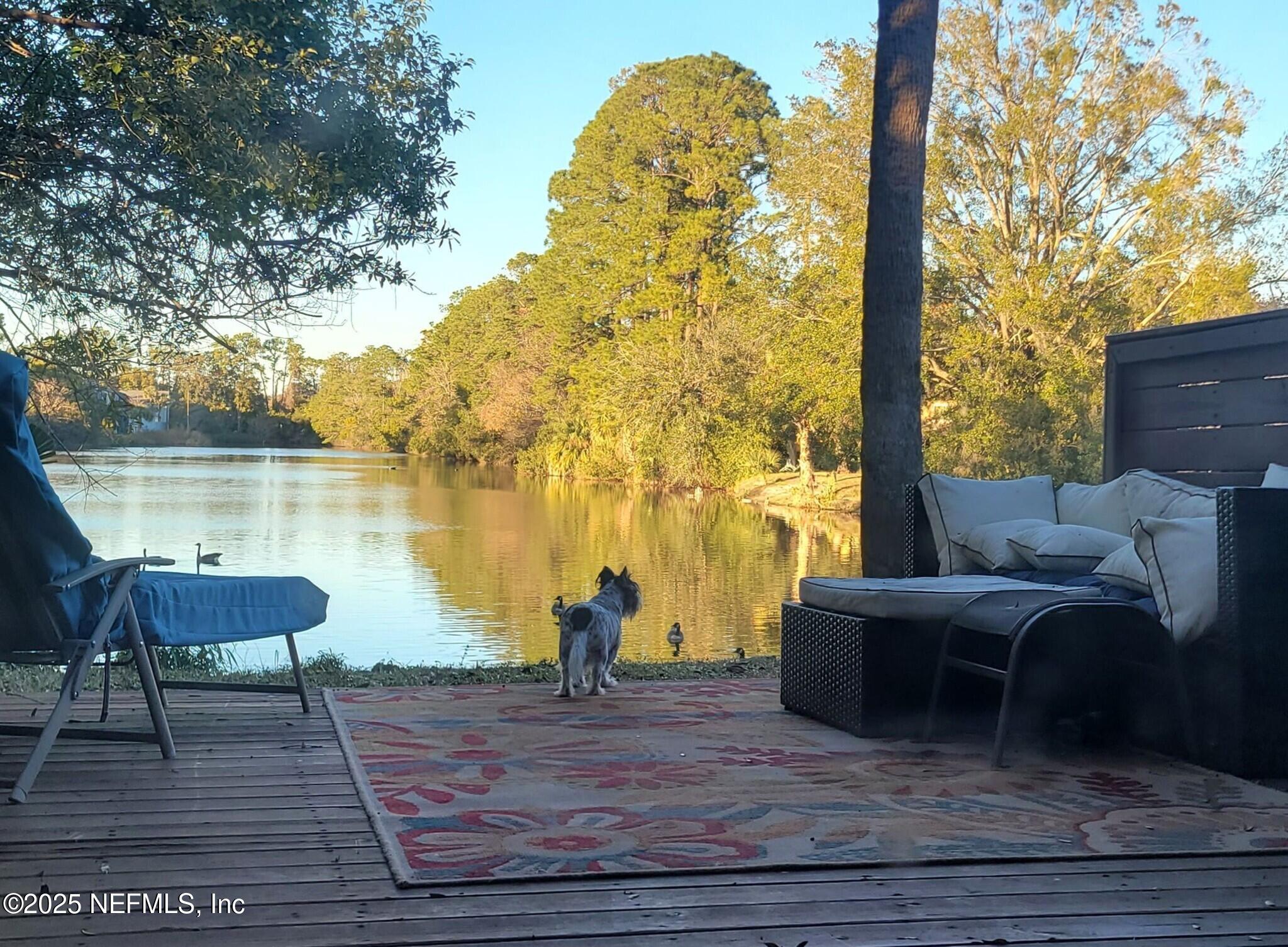 a view of a lake with couches in patio