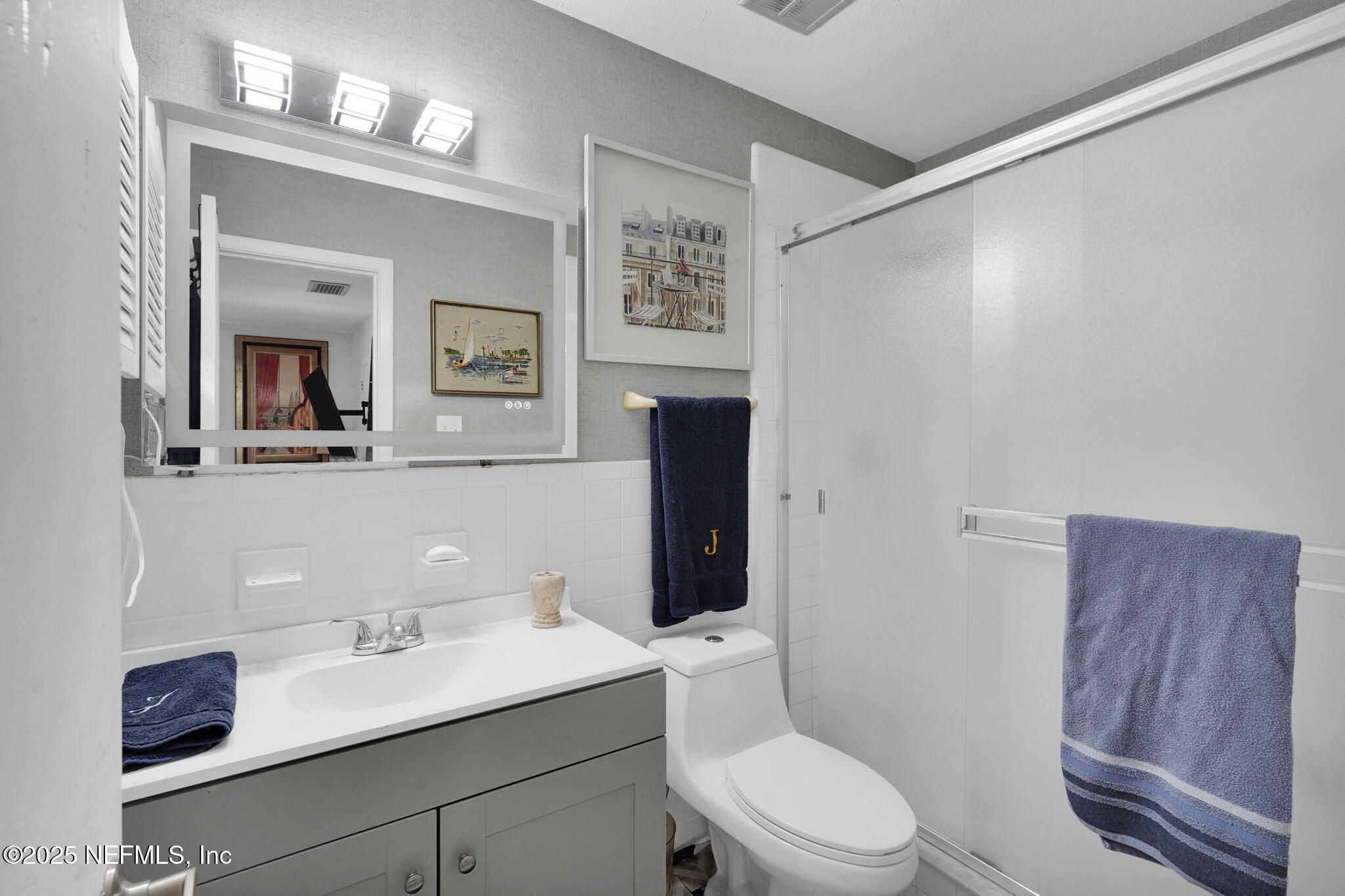 9901 Regency Square Boulevard, Unit 90 Jacksonville, FL 32225 - Photo 15 of 27 a bathroom with a toilet a sink and mirror