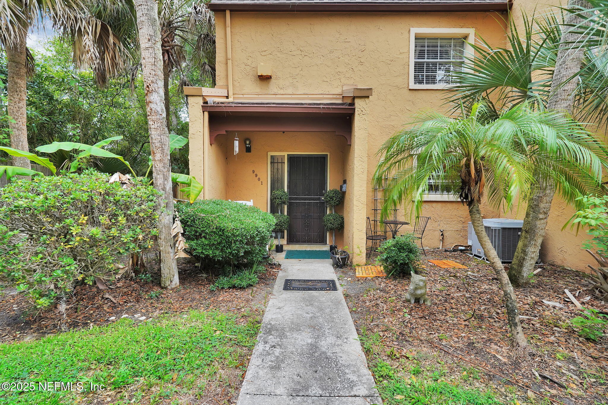 9901 Regency Square Boulevard, Unit 90 Jacksonville, FL 32225 - Photo 2 of 27 a front view of a house with yard and green space