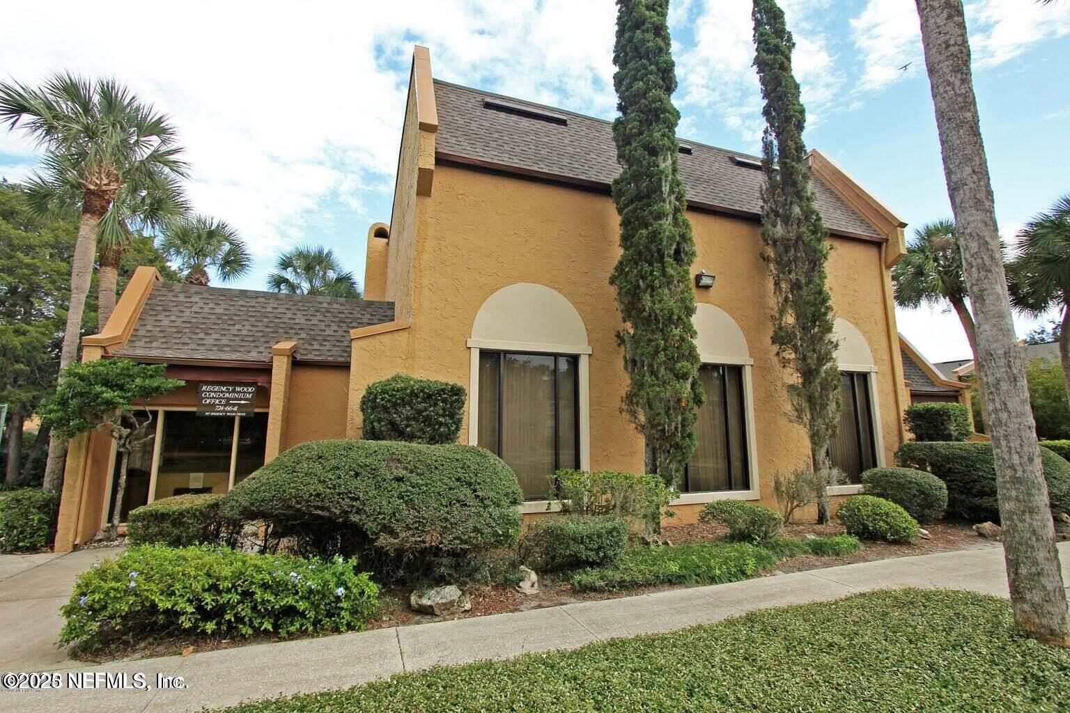 9901 Regency Square Boulevard, Unit 90 Jacksonville, FL 32225 - Photo 26 of 27 a front view of a house with a yard and garage