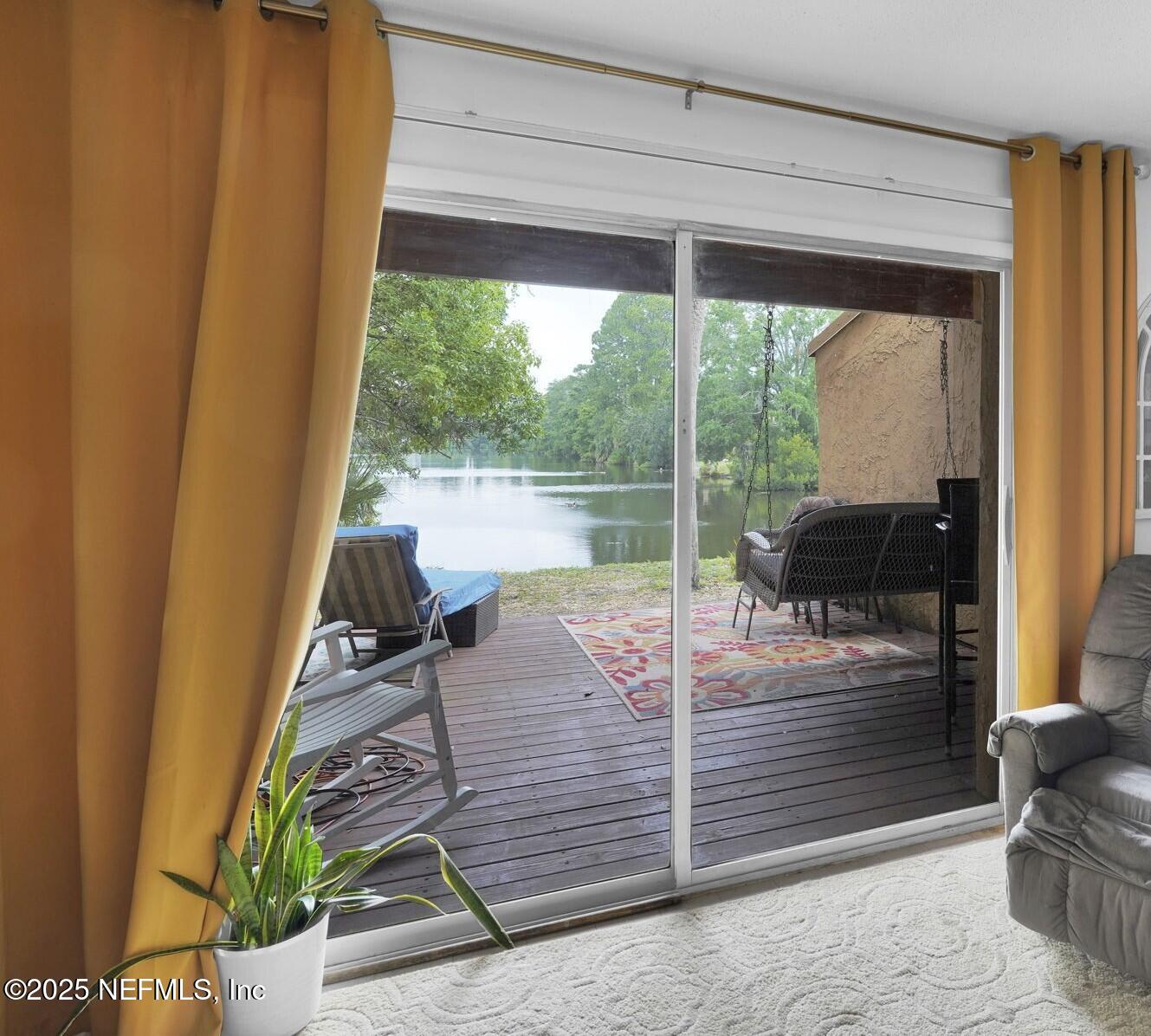 9901 Regency Square Boulevard, Unit 90 Jacksonville, FL 32225 - Photo 10 of 27 a room with a balcony a bed and glass door