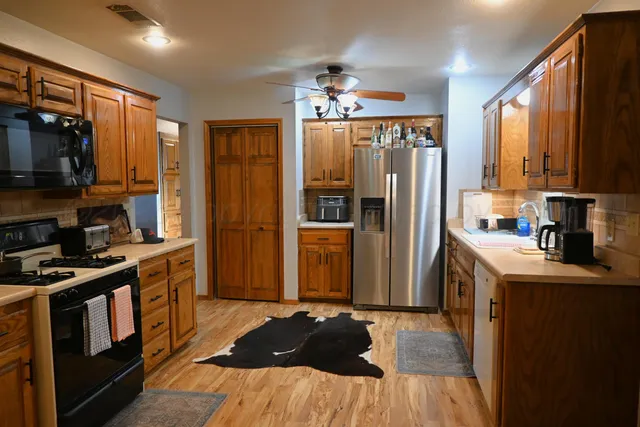 a kitchen with stainless steel appliances granite countertop a refrigerator a stove top oven a sink and dishwasher
