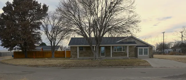 a view of a house with a yard and large trees