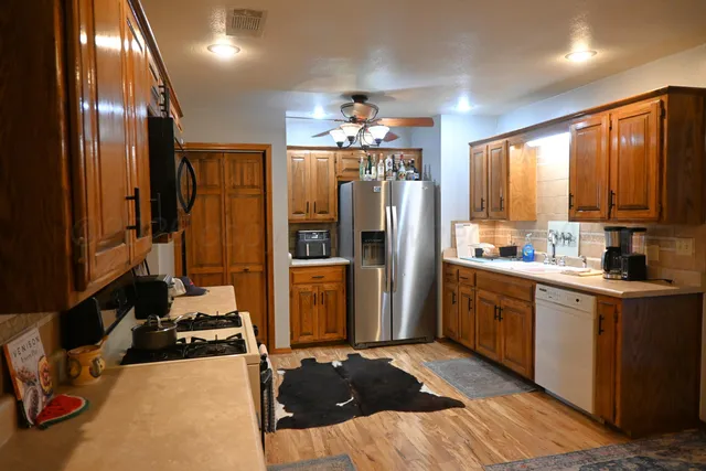 a kitchen with stainless steel appliances granite countertop a refrigerator a stove and a sink