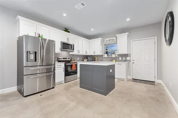 a kitchen with stainless steel appliances granite countertop a refrigerator sink and microwave
