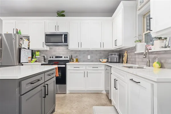 a kitchen with white cabinets sink and stainless steel appliances