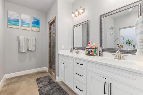 a spacious bathroom with a double vanity sink mirror and shower