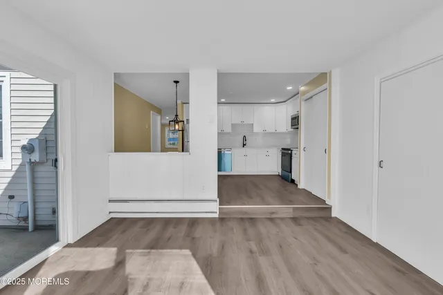 a view of empty room with wooden floor and window