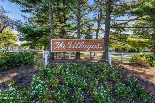 a sign that is sitting in front of a tree