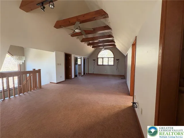 en empty room with windows and ceiling fan