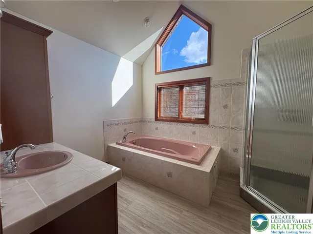 a bathroom with a tub sink and mirror