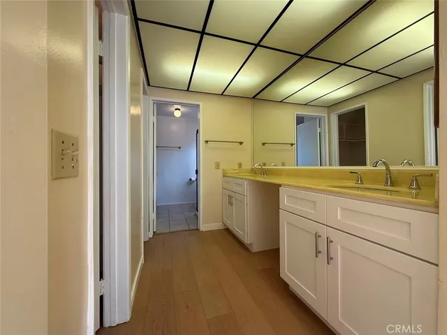 a bathroom with a sink and mirror with shower