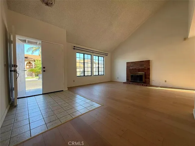 an empty room with windows and fireplace