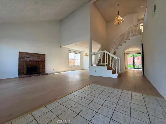 an empty room with windows and fireplace