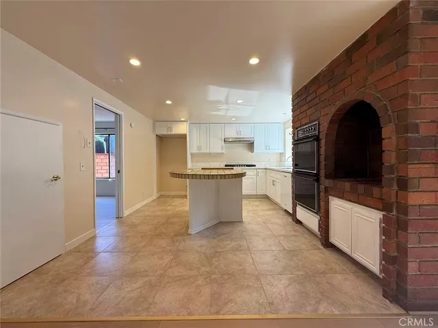 a kitchen with stainless steel appliances granite countertop a refrigerator and a stove