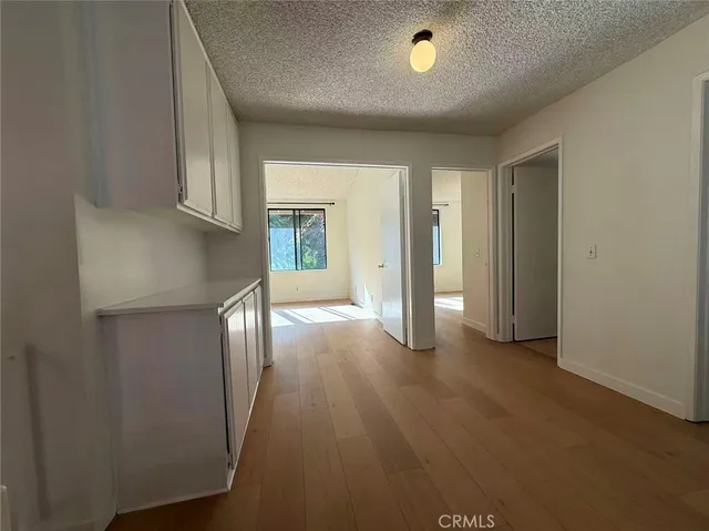 an empty room with windows and cabinet