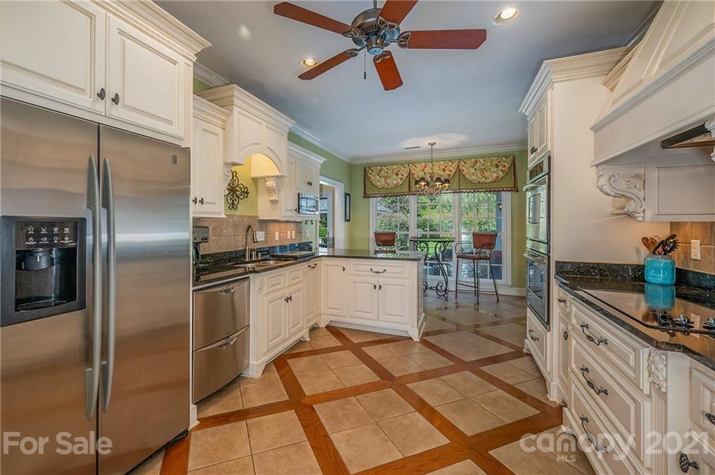 120 Pleasant Hill Road Landrum, SC 29356 - Photo 12 of 25 a kitchen with stainless steel appliances kitchen island granite countertop a refrigerator a sink a stove and white cabinets with wooden floor