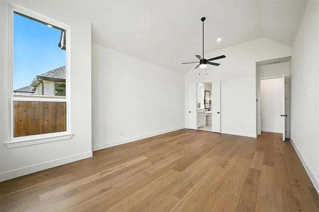 a view of empty room with wooden floor and window