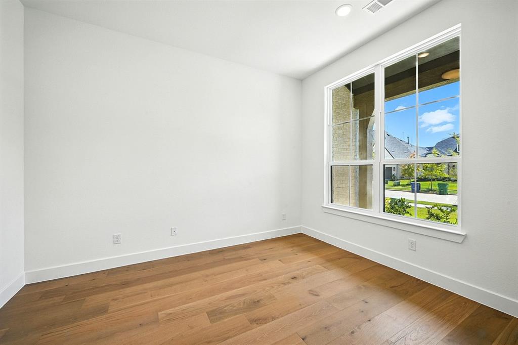4013 Trellis Drive Prosper, TX 75078 - Photo 19 of 35 an empty room with wooden floor and windows