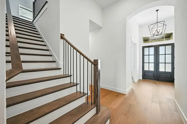 a view of a hallway with wooden floor and staircase
