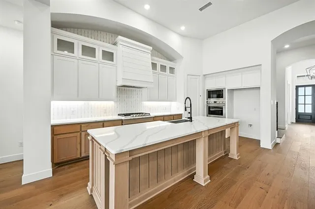 a kitchen with stainless steel appliances a stove a sink dishwasher and a refrigerator