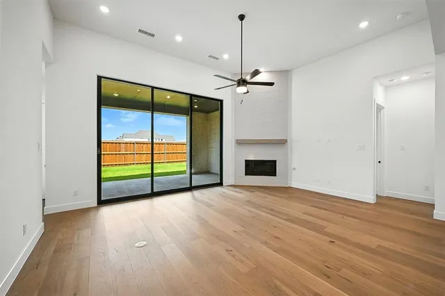 a view of an empty room with a fireplace and a window