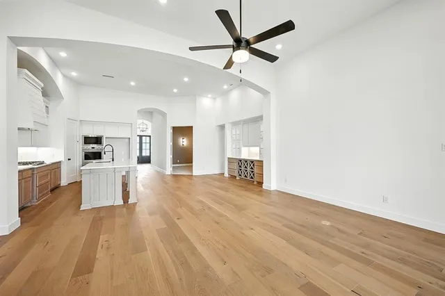 a view of a kitchen with a sink and dishwasher a refrigerator with wooden floor